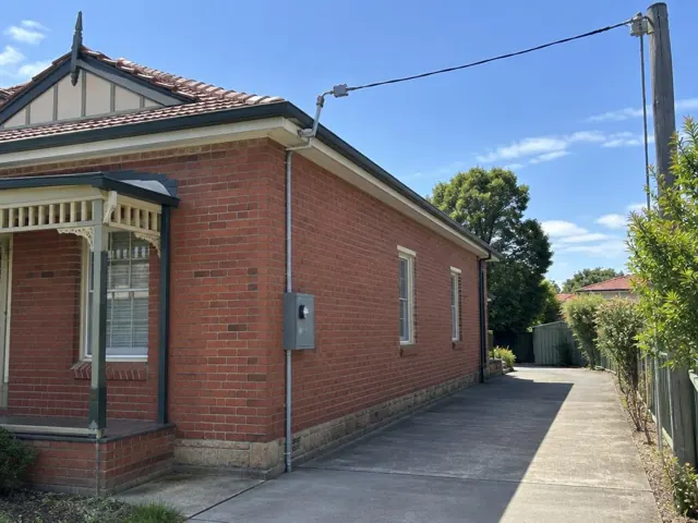Brick house with overhead service cable and point-of-attachment bracket on the roofline in Hamilton